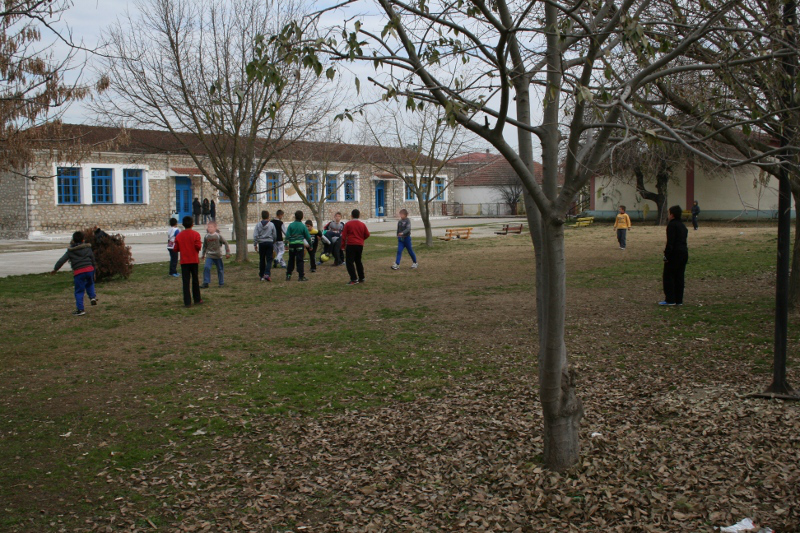 μαθητές παίζουν ποδόσφαιρο στην αυλή του σχολείου